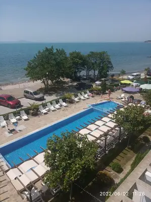 an overhead view of a swimming pool with lounge chairs and the ocean at Vilmar Studio in Pomorie