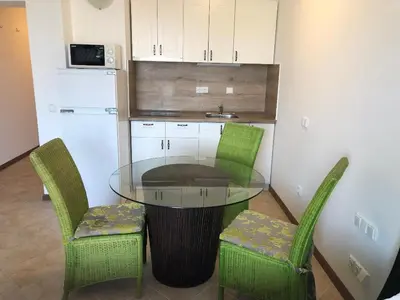 a glass table and two chairs in a kitchen at Oasis Resort & Spa Cozy Studio in Lozenets