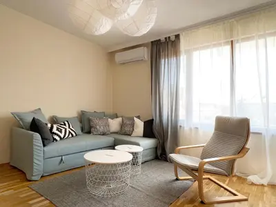 a living room with a couch and a table and chairs at Lovely Apartment with Balcony in Pomorie Old Town by Flat Mаnаger in Pomorie