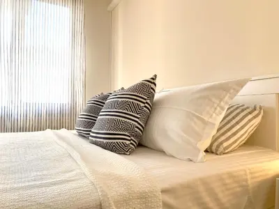 a bedroom with a bed with pillows and a window at Lovely Apartment with Balcony in Pomorie Old Town by Flat Mаnаger in Pomorie