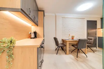 a kitchen and dining room with a table and chairs at Deluxe and Central Garden Apartment in Varna City