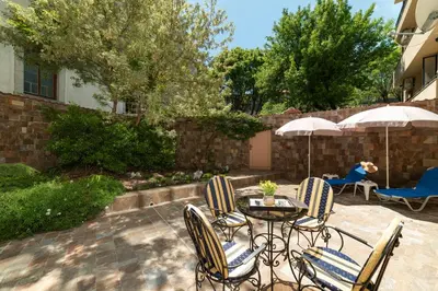 a patio with a table and chairs and umbrellas at Deluxe and Central Garden Apartment in Varna City