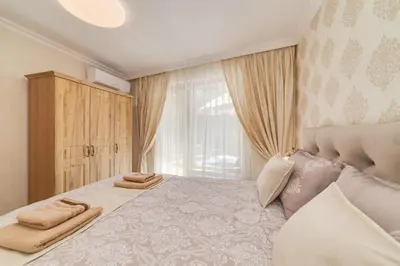 a bedroom with a large bed and a window at Deluxe and Central Garden Apartment in Varna City