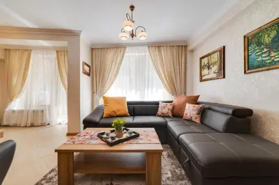 a living room with a leather couch and a table at Deluxe and Central Garden Apartment in Varna City