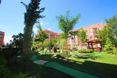 a park with a green slide in front of a building at Апартамент в Рейнбоу 3 in Sunny Beach