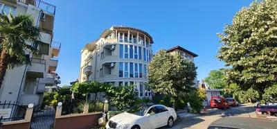 a white car parked in front of a building at Къща за гости Беглик Таш 2 in Primorsko
