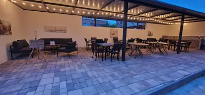 an outdoor patio with tables and chairs and lights at Къща за гости Беглик Таш 2 in Primorsko