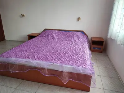a bed with a purple comforter in a room at Fa Mol in Sunny Beach