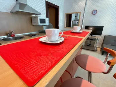 a kitchen with a red counter top with two cups on it at Sunny Studio in Sunny Beach by Flat Mаnаger in Sunny Beach