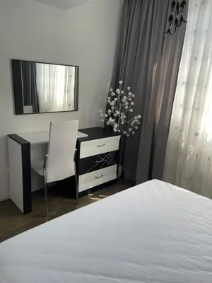 a bedroom with a bed and a desk and a mirror at My Sweet Home in Burgas City