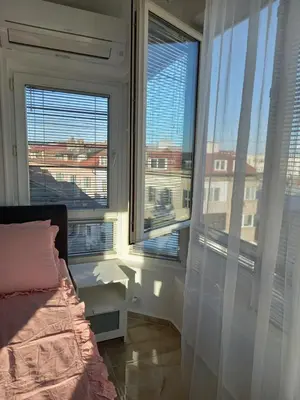a bedroom with a bed and two large windows at Perla 2 studio in Burgas City