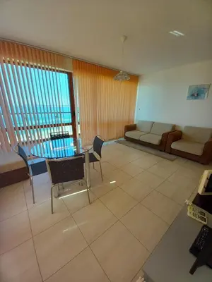 a living room with a couch and a table at Апартаменти СЪНИ БЕЙ in Sunny Beach