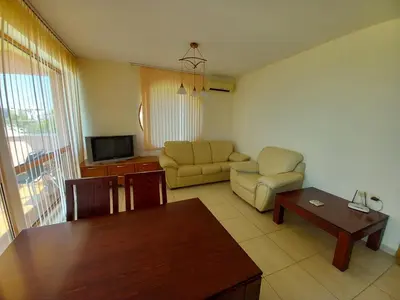 a living room with a couch and a table at Апартаменти СЪНИ БЕЙ in Sunny Beach