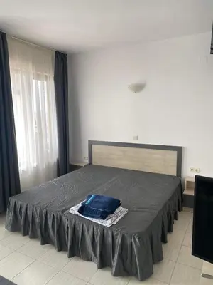 a bedroom with a bed with a blue blanket on it at Luxory Apartament on the Seaside, Gradina beach, St Nicholas Complex in Chernomorets