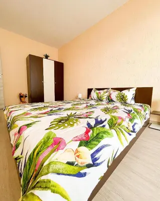 a bedroom with a large bed with a colorful blanket at Blue Sky Apartments in Nesebar