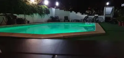 a pool at night with green water in it at Sozopol Romance Apartments in Sozopol