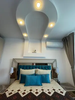 a bedroom with a large bed with a blue headboard at Brand new first line Sea view 1 bedroom apartment in Burgas City