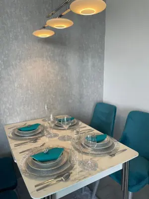 a table with plates and wine glasses on it at Brand new first line Sea view 1 bedroom apartment in Burgas City