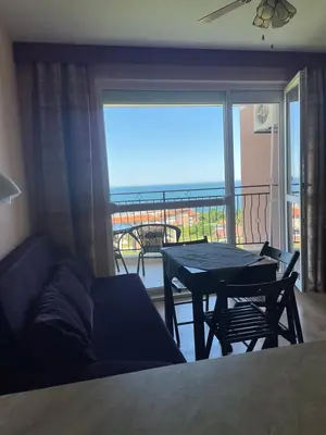 a living room with a couch and a table and a balcony at Nieli-1 SP apartments in Byala