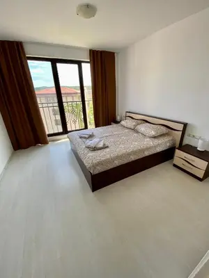 a bedroom with a bed and a large window at Green Life Private apartments in Sozopol