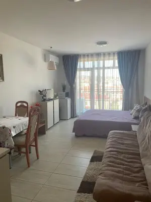 a bedroom with a bed and a couch and a window at Green Life Private apartments in Sozopol