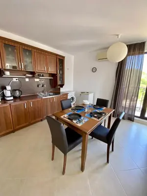 a kitchen with a wooden table and chairs at Green Life Private apartments in Sozopol