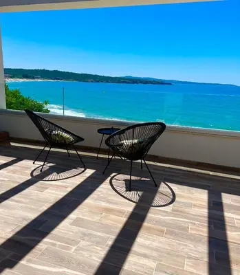 two chairs on a balcony with a view of the ocean at Olive Villas Beach Hotel in Sozopol