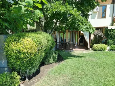 a hedge in front of a house with a tree at Къща на брега на морето Свети Влас, Garden of Eden in Sveti Vlas