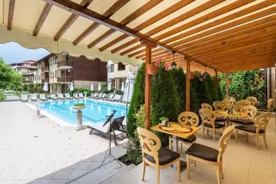 a patio with tables and chairs next to a pool at Къща на брега на морето Свети Влас, Garden of Eden in Sveti Vlas