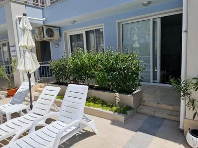 two white chairs and an umbrella on a porch at Sunny Dream Apartments Sunny Beach Bulgarien Sonnenstrand in Sunny Beach