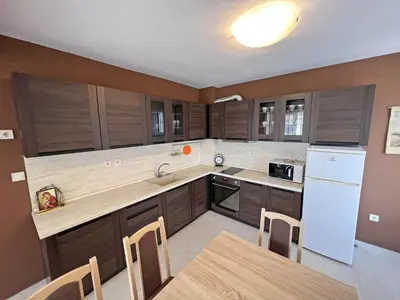 a kitchen with wooden cabinets and a white refrigerator at Valemar Apartments in Pomorie