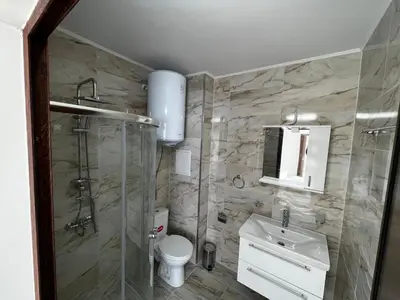 a bathroom with a shower and a toilet and a sink at Valemar Apartments in Pomorie