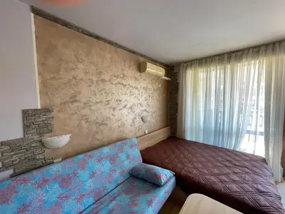 a living room with a blue couch and a wall at Lovely Studio in a Complex with a Pool by Flat Mаnаger in Sveti Vlas