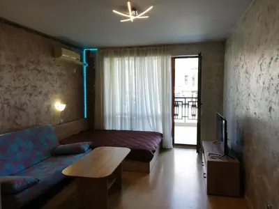 a living room with a couch and a tv at Lovely Studio in a Complex with a Pool by Flat Mаnаger in Sveti Vlas