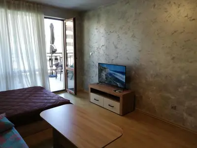 a living room with a television on a wooden table at Lovely Studio in a Complex with a Pool by Flat Mаnаger in Sveti Vlas