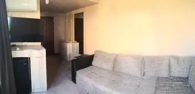 a living room with a couch and a flat screen tv at euroHOTEL Primorsko in Primorsko