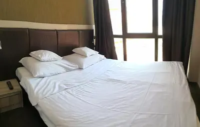 a large bed with white sheets and pillows on it at euroHOTEL Primorsko in Primorsko