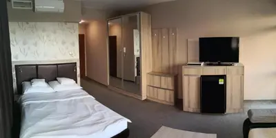 a hotel room with a bed and a flat screen tv at euroHOTEL Primorsko in Primorsko