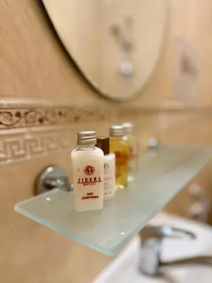 a bathroom shelf with a bottle of medicine on it at Rooms in New Town Nessebar by Flat Mаnаger in Nesebar