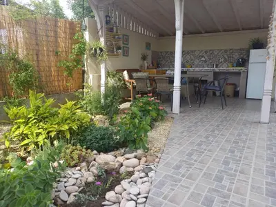 a patio with a garden with a table and chairs at вила ФЛОРА in Chernomorets