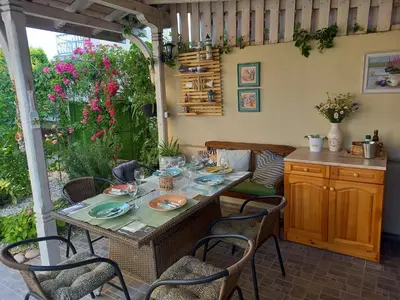 a table and chairs in a patio with a table at вила ФЛОРА in Chernomorets