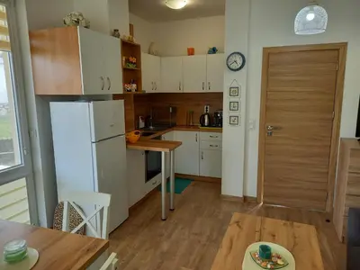 a kitchen with a white refrigerator and a table at вила ФЛОРА in Chernomorets