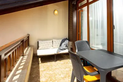 a balcony with a couch and a table and chairs at Studio Maré Chernomorets in Chernomorets