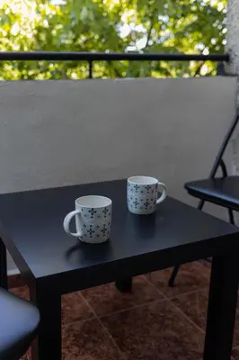 two coffee cups sitting on a black table at Lovely 1BD Flat near the Sea Garden by Flat Mаnаger in Burgas City