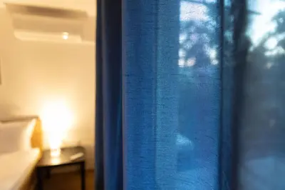 a blue curtain in a room with a bed at Lovely 1BD Flat near the Sea Garden by Flat Mаnаger in Burgas City
