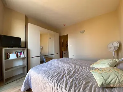 a bedroom with a bed and a flat screen tv at AVALON D608 Apartment BIG BAOLCONY Sunny Beach in Sunny Beach