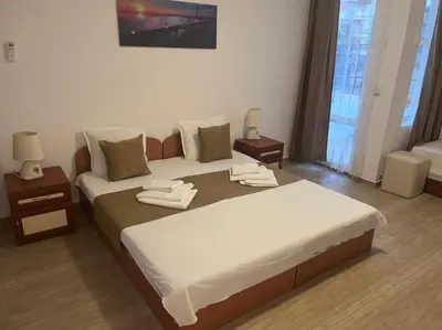 a bedroom with a large bed and two night stands at Къща за гости CANAVAN'S in Ravda