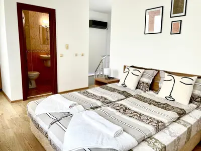 a bedroom with a large bed with towels on it at Penthouse Panorama Sea View Apt. Pomorie in Pomorie