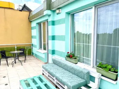 a balcony with a bench and a table and windows at Penthouse Panorama Sea View Apt. Pomorie in Pomorie