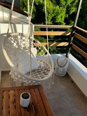 a white swing on a porch with a pillow at A&K Guest Studio in Varna City